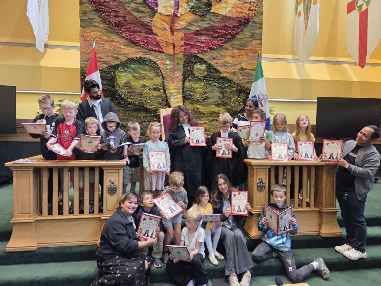 Speaker Clarke with children and activity book